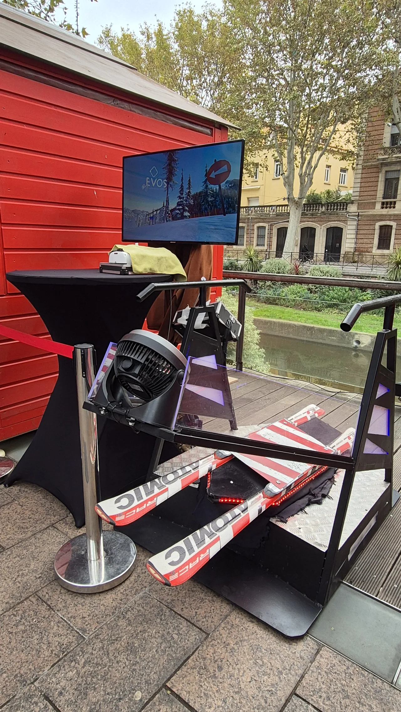Vue rapprochée du simulateur ski VR avec skis Atomic rouge et blanc sur la plate-forme noire