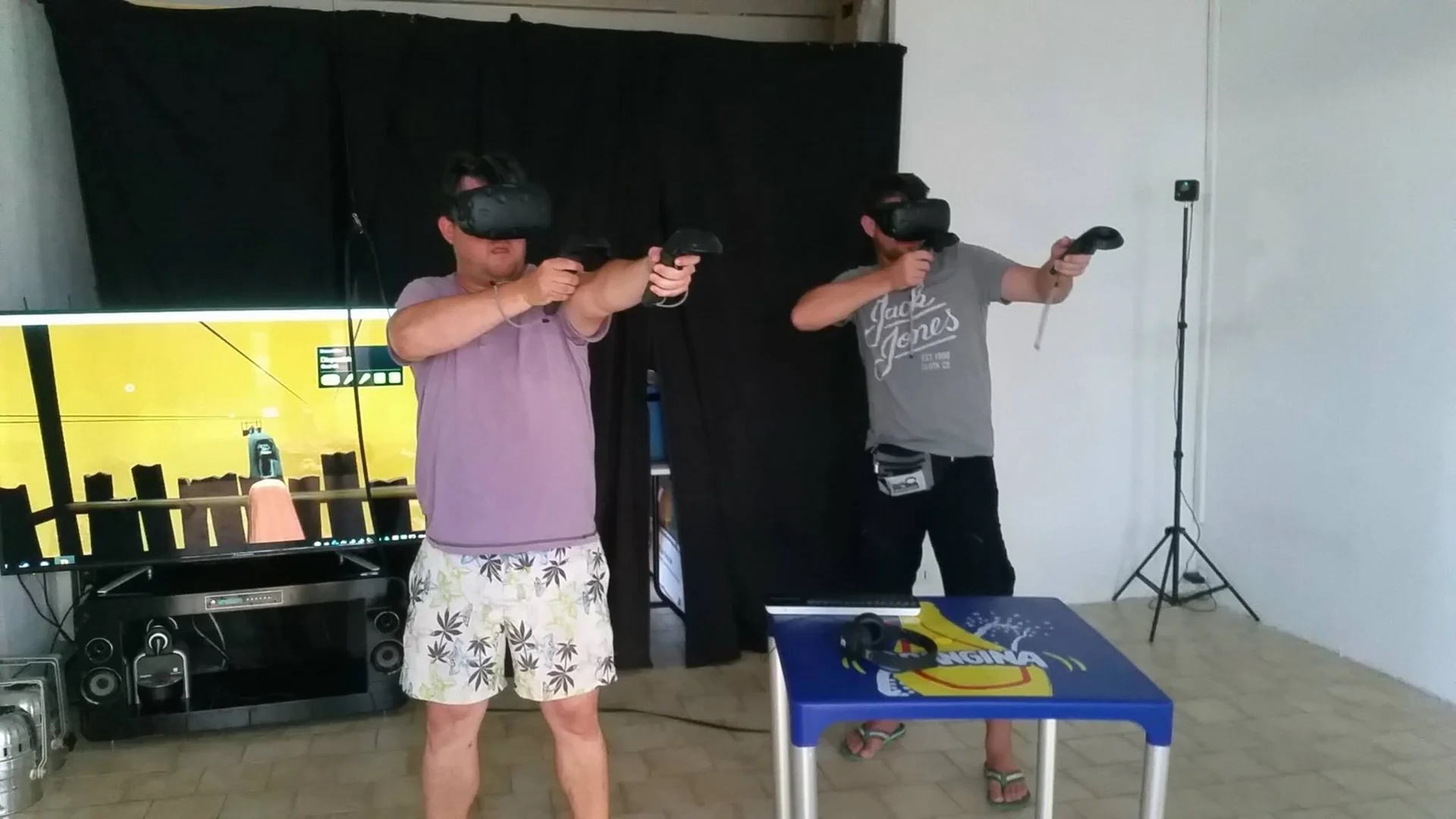 Deux participants en session HTC Vive room-scale debout avec casque et manettes 6DoF dans l'espace intérieur de la boutique