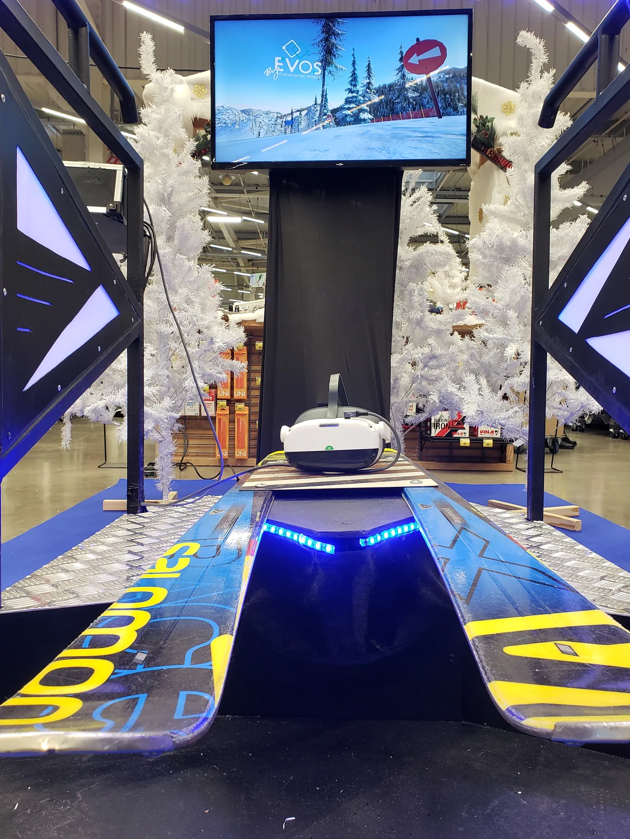 Simulateur ski VR avec skis Salomon bleus jaunes et écran TV de retransmission dans le rayon Décathlon