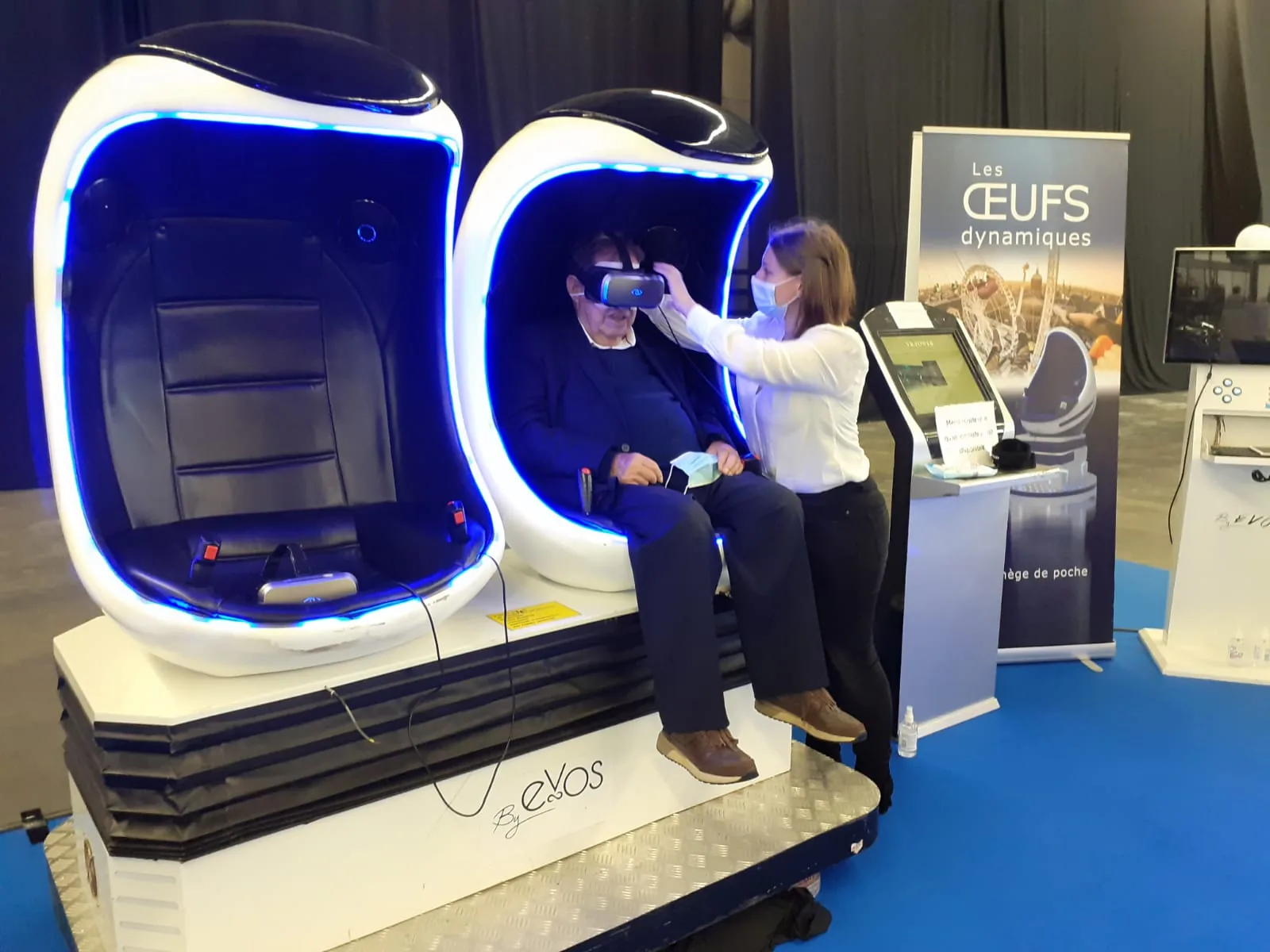 Participant senior casqué VR dans le Cocooning accompagné par une animatrice pendant la Foire d'Auxerre