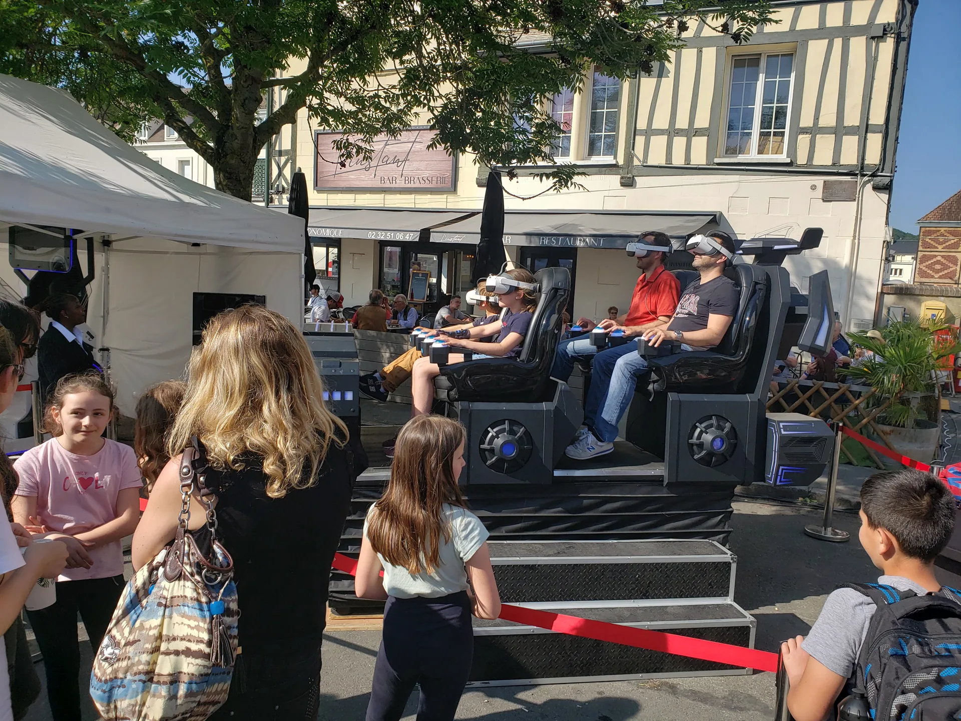 Quatre participants casqués VR à bord d'un simulateur Sensation motorisé pendant la Foire de Vernon