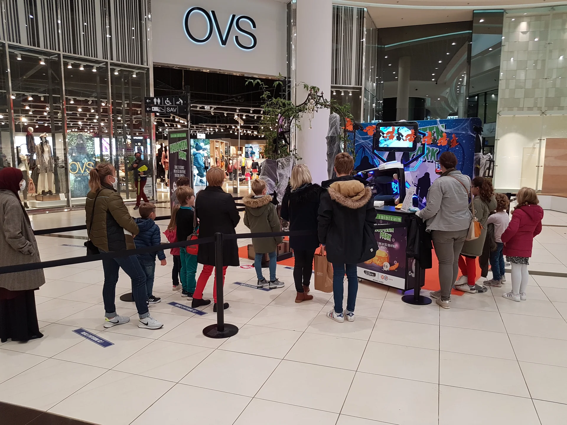 File d'attente respectant la distanciation devant le simulateur SOL 360 VR face à OVS dans la galerie