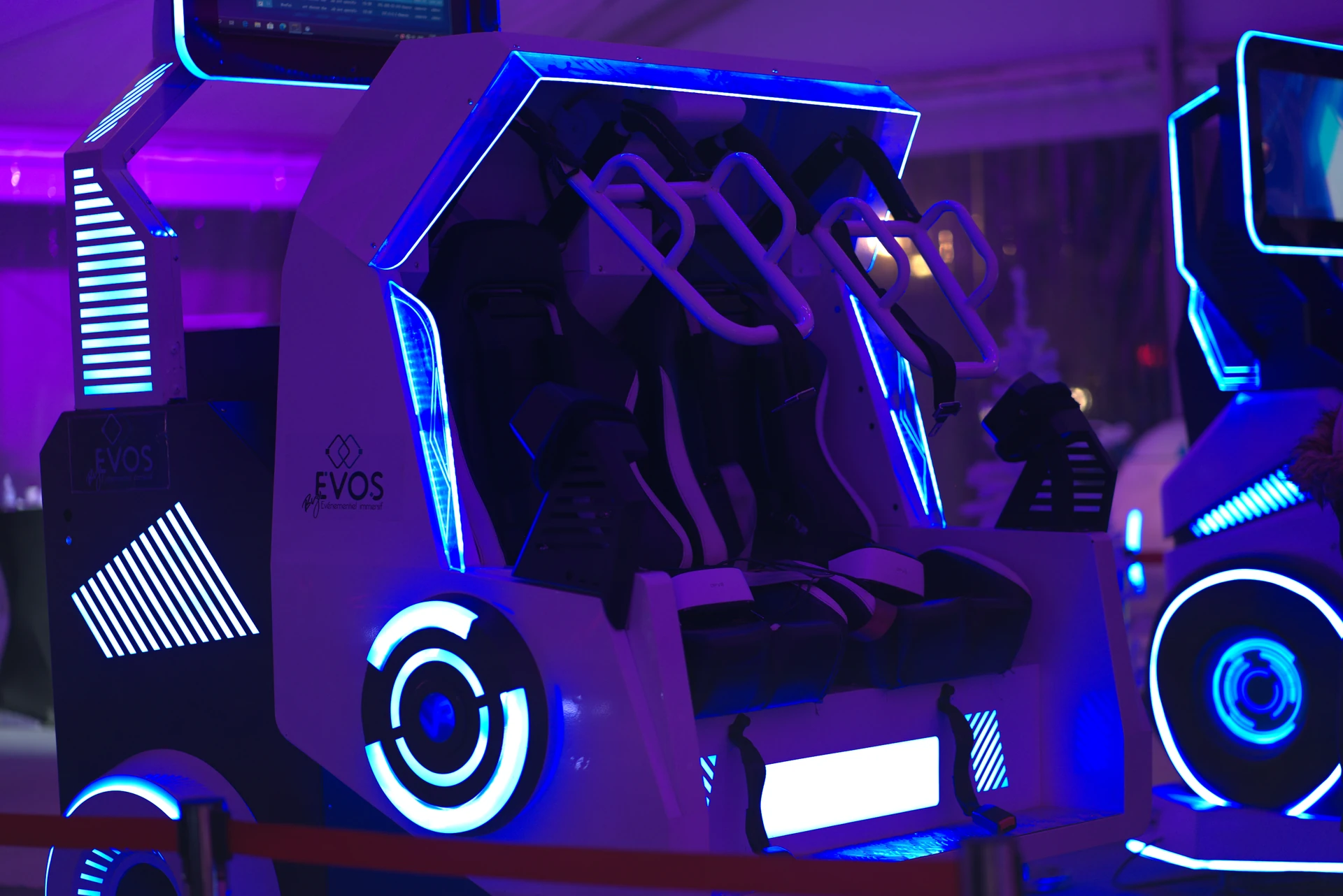 Simulateur double 360 By Evos installé en animation événementielle Sud-Ouest sous éclairage scénique bleu et magenta