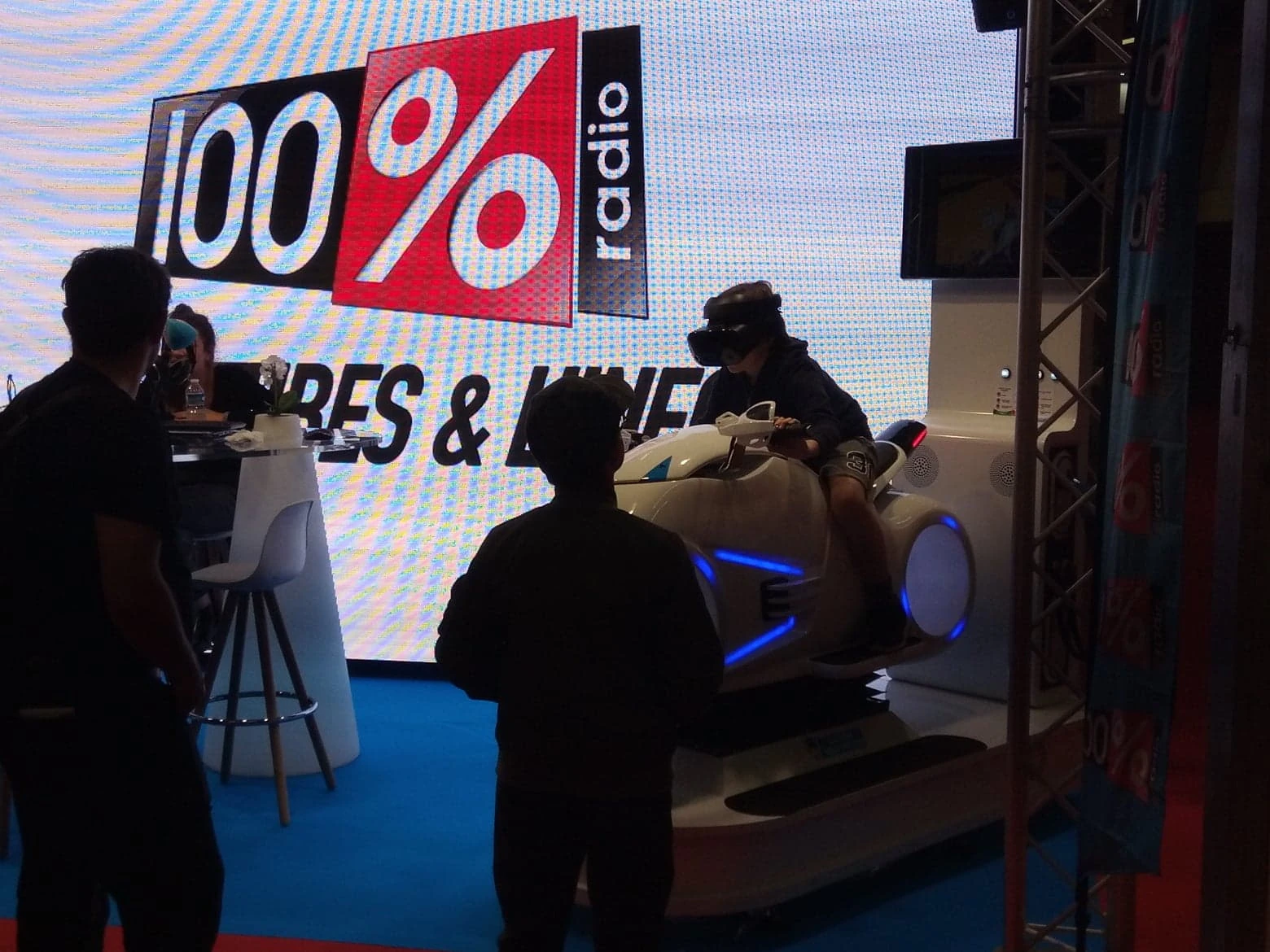 Simulateur moto VR aérodynamique avec participant devant écran géant 100% Radio à la Foire de Toulouse