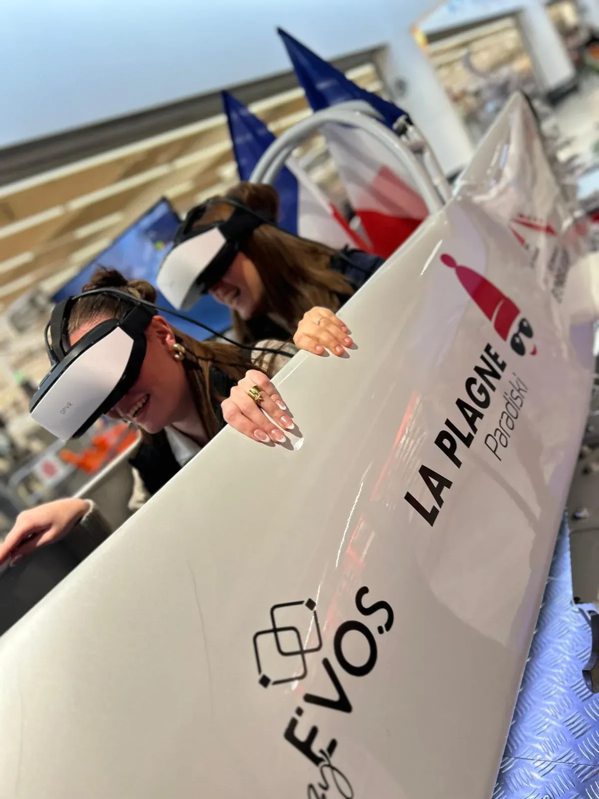 Deux participantes en casques VR à bord du simulateur bobsleigh By Evos