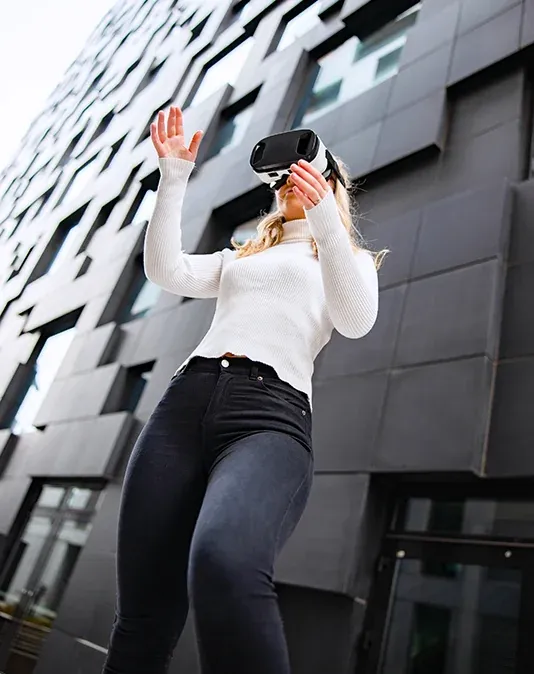 Femme blonde portant un casque VR en extérieur sous la lumière naturelle