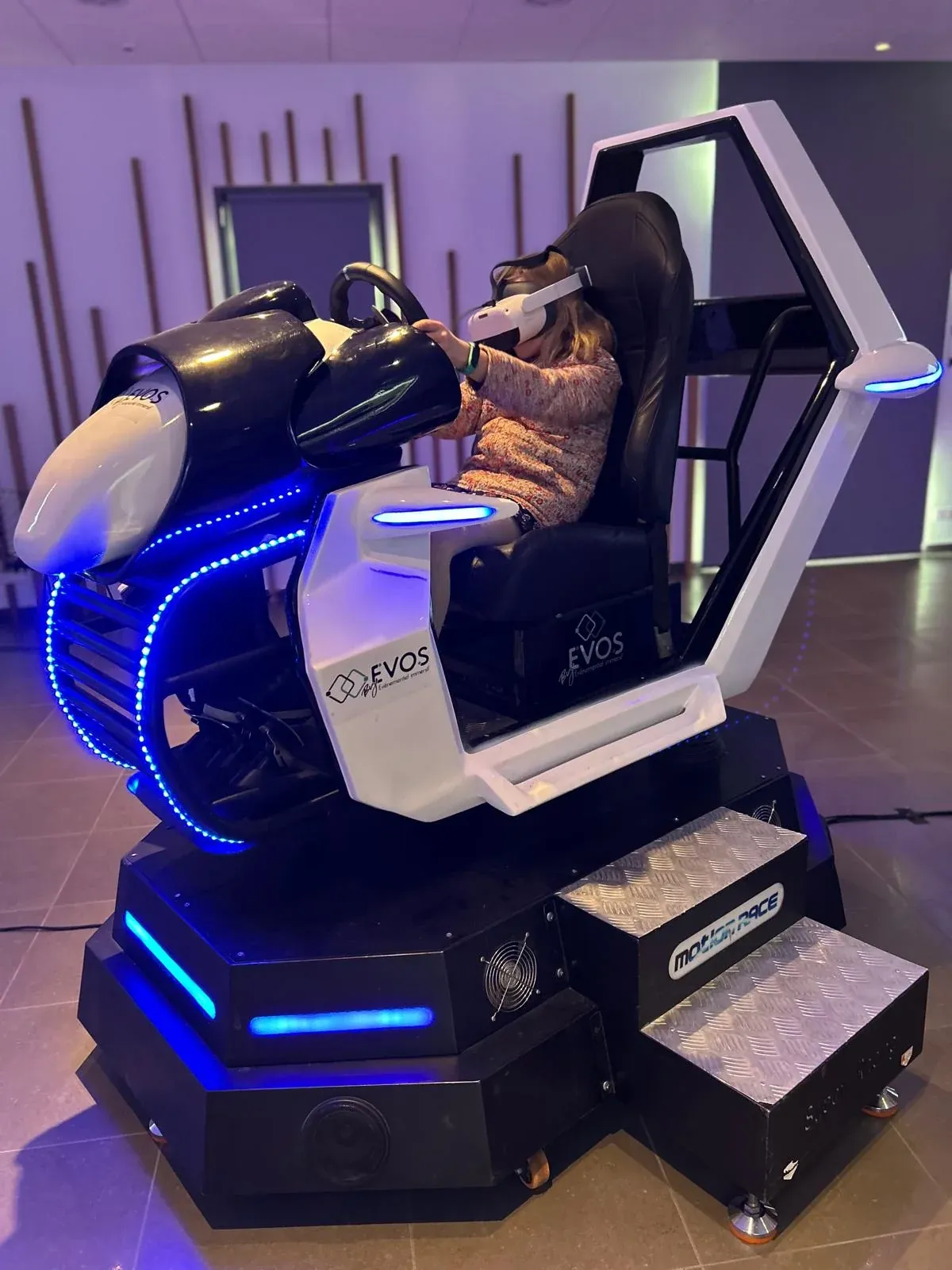 Participant sur simulateur scooter des neiges VR lors d'une animation en intérieur