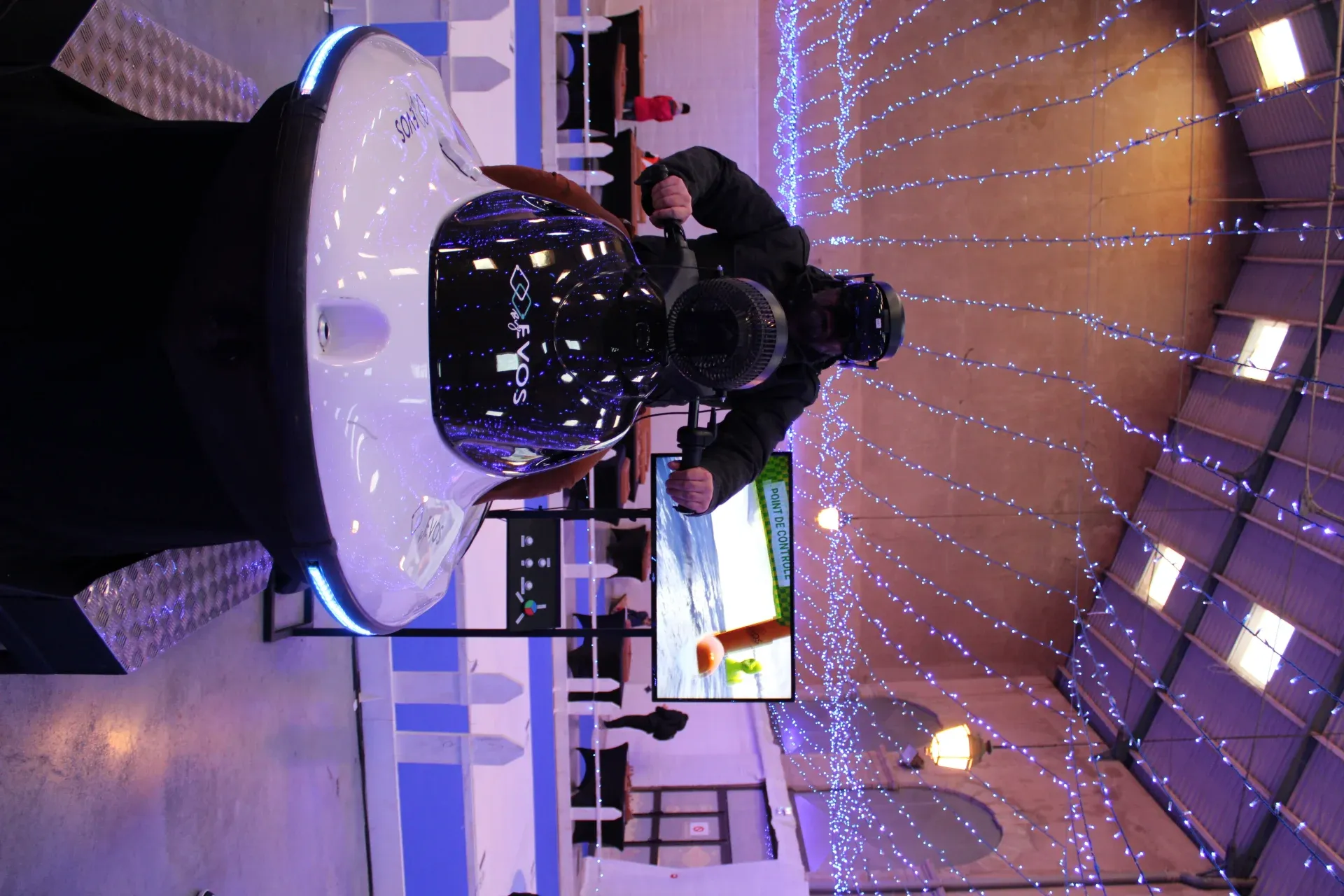 Participante en casque VR installée sur simulateur jet ski lors d'une animation en galerie marchande