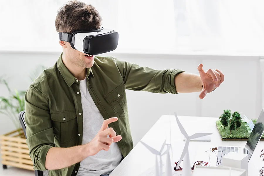 Architecte portant un casque VR et manipulant une maquette 3D dans un bureau