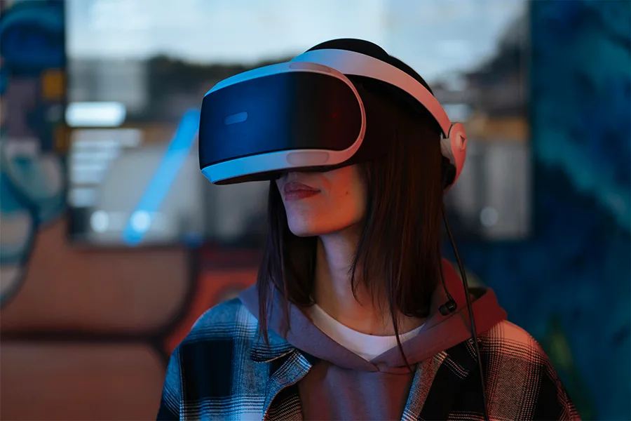 Femme portant un casque PlayStation VR entourée d'effets holographiques bleus