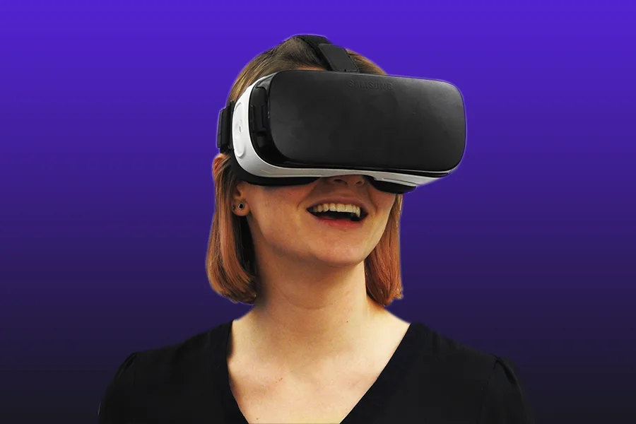 Femme souriante portant un casque de réalité virtuelle sur fond violet