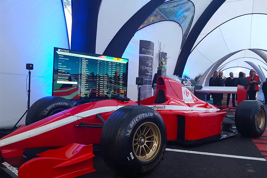 Simulateur Formule 1 rouge By Evos avec écrans de circuit en arrière-plan