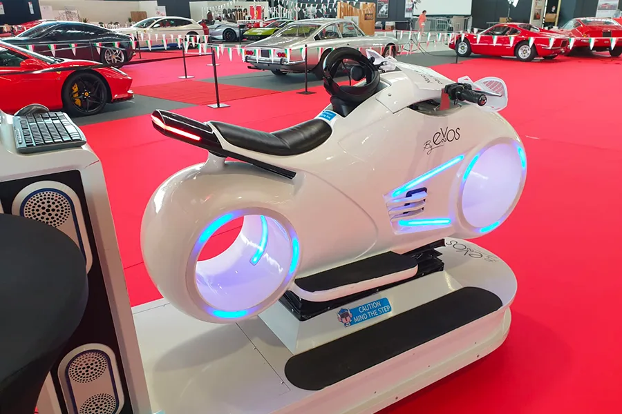 Simulateur moto VR blanc By Evos exposé dans un salon automobile
