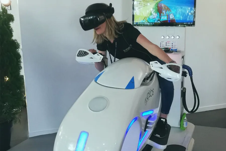 Participante sur le simulateur moto VR By Evos lors d'un salon professionnel