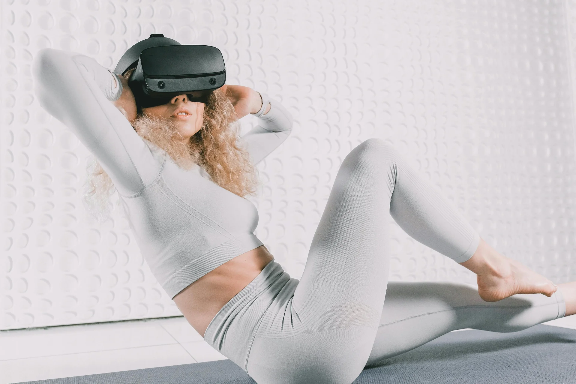 Femme en tenue blanche portant un casque VR, expérience sport immersive en réalité virtuelle