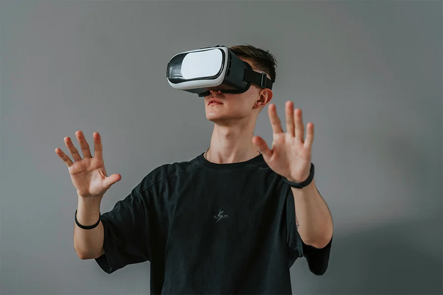 Jeune homme portant un casque de réalité virtuelle en immersion dans un environnement 3D