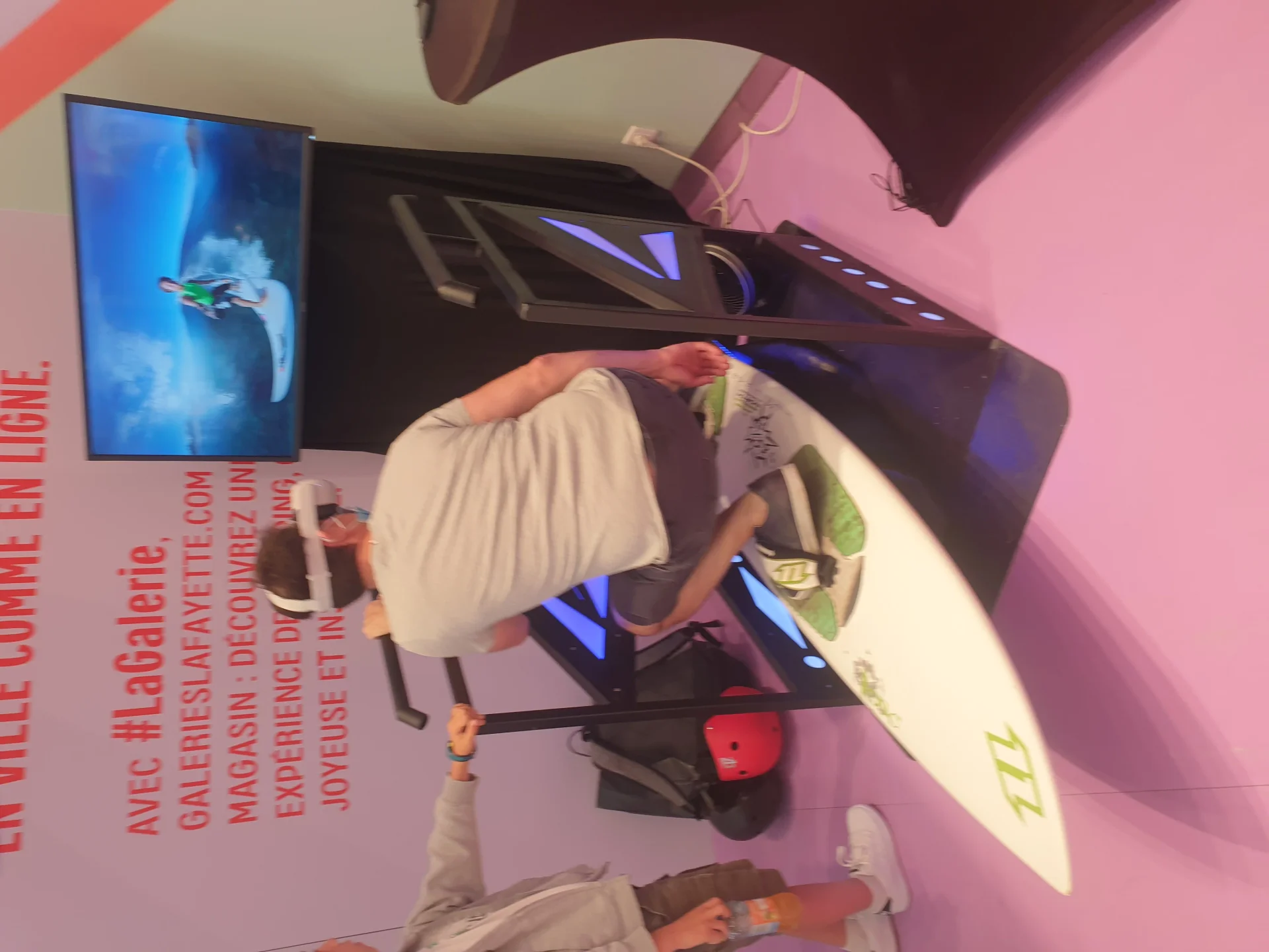 Participant en position surf sur le simulateur de vague VR By Evos lors d'une animation événementielle