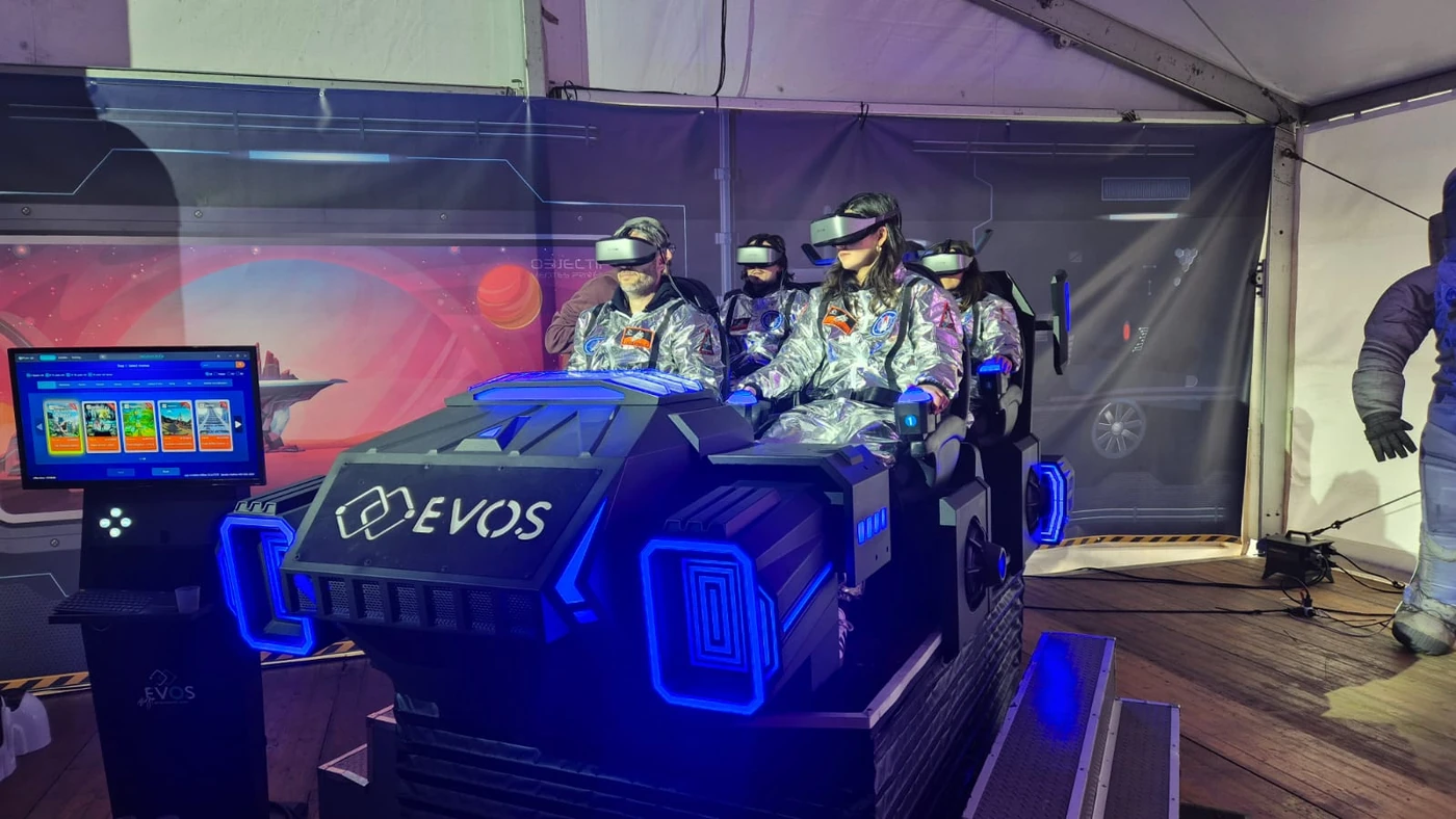 Quatre participants en casque VR à bord de la navette Evos sous tente lors d'un séminaire