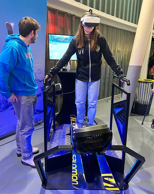 Simulateur ski VR By Evos avec animateur accompagnant une participante