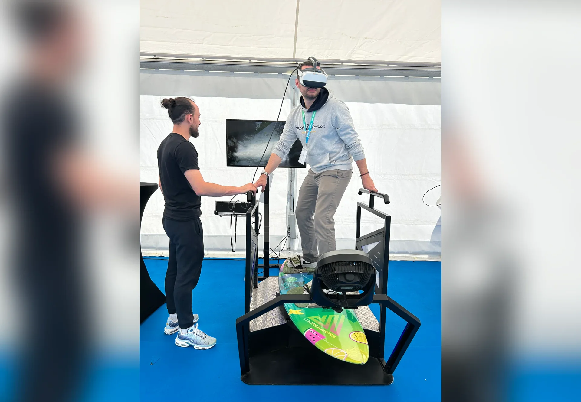Animateur guidant un visiteur en casque VR sur le simulateur de surf